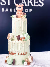 Load image into Gallery viewer, Size: 4-6&quot; two tier. Icing exterior: pastel green. Accent: greens, browns, gold. 
