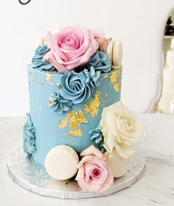 Size: 6" one tier. Icing exterior: dusty blue, denim blue. Accent: white, gold, pink.