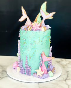Size: 4" One tier. Icing Exterior: Teal. Accents: pink, purple, gold.