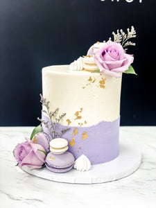 Size: 6" one tier. Icing exterior: white. Accents: gold, purple, white.