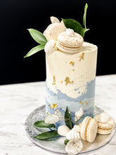 Load image into Gallery viewer, Size: 4&quot; one tier. Icing exterior: white. Accent: shades of dusty blue, greenry.
