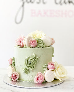 Size: 6" one tier. Icing exterior: sage green. Accent: white/pink